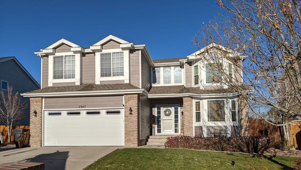 White Regency Series garage door with decorative windows installed on a Pueblo-area home