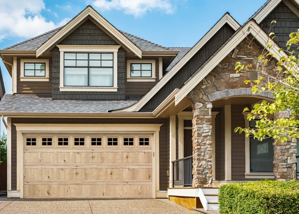 Bi-Directional wood grain garage door in Natural on a light craftsman home